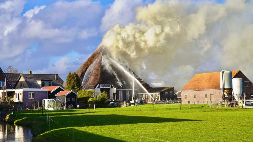 Veel rook bij uitslaande brand in stolpboerderij met rieten dak in Wervershoof